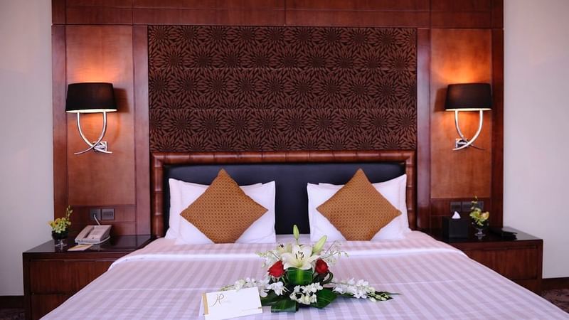 Flower bouquet arranged on the bed in Club Suite at Al Hamra Palace by Warwick Riyadhd