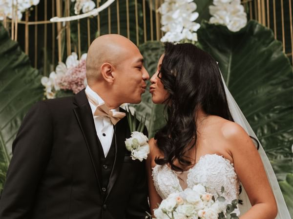 Bride & groom kissing each other at Hotel Maya Kuala Lumpur City Centre