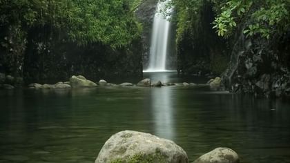 Biausevu Village with Serene waterfall by dark rocks and a calm pond near Tambua Sands Beach Resort