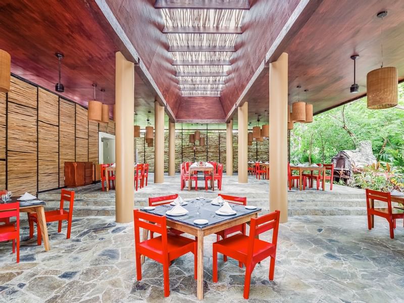 Dining tables arranged, overlooking the forest at The Explorean Cozumel