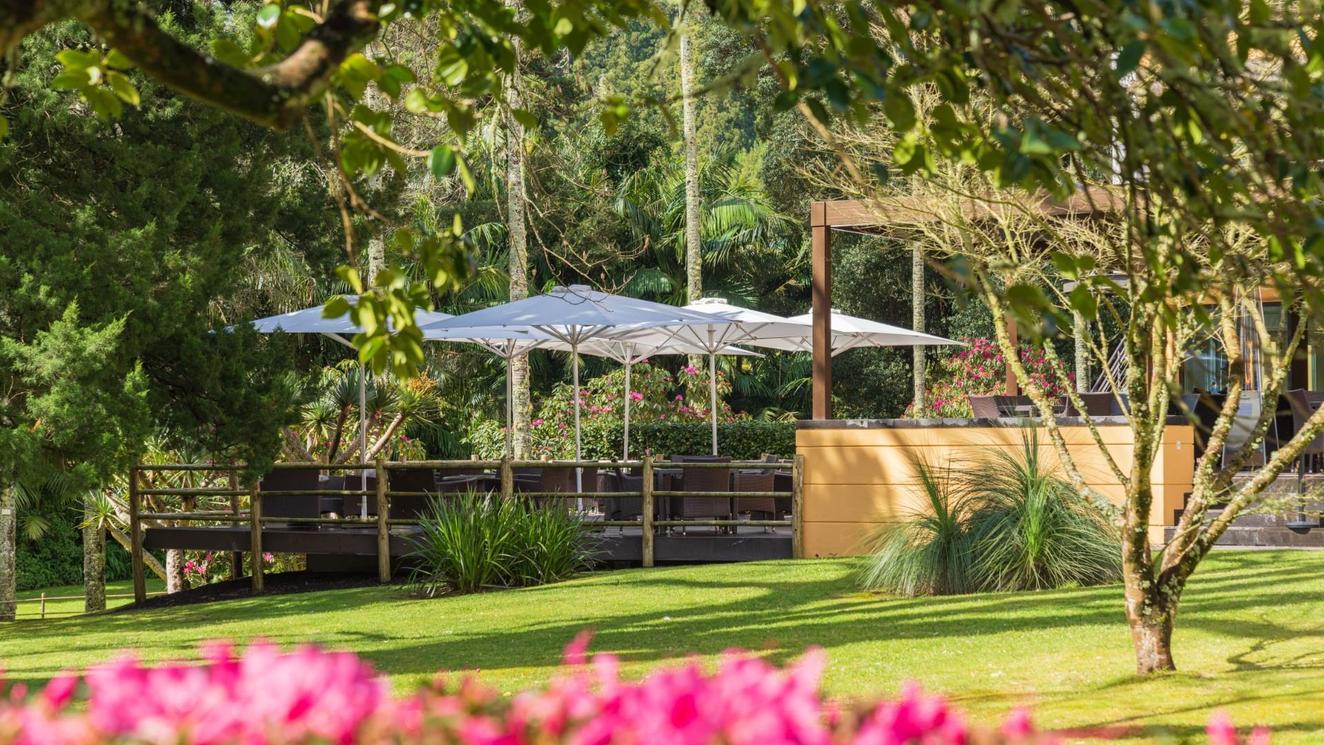 Outdoor dining area in The Gardener Restaurant with flowers & trees at Terra Nostra Garden Hotel