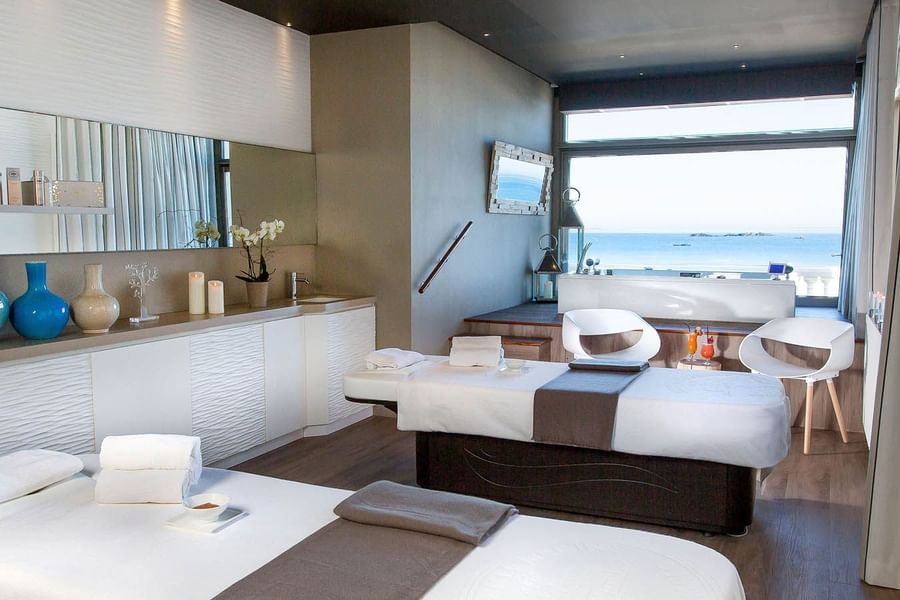 spa room with massage beds & amenities and large window overlooking the ocean in St Malo spa at Le Grand Hôtel des Thermes