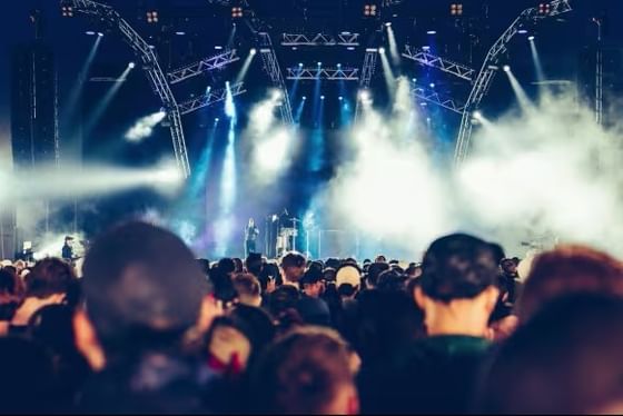 Large crowd watching a concert stage with dramatic blue lighting and fog effects at Parklife Festival