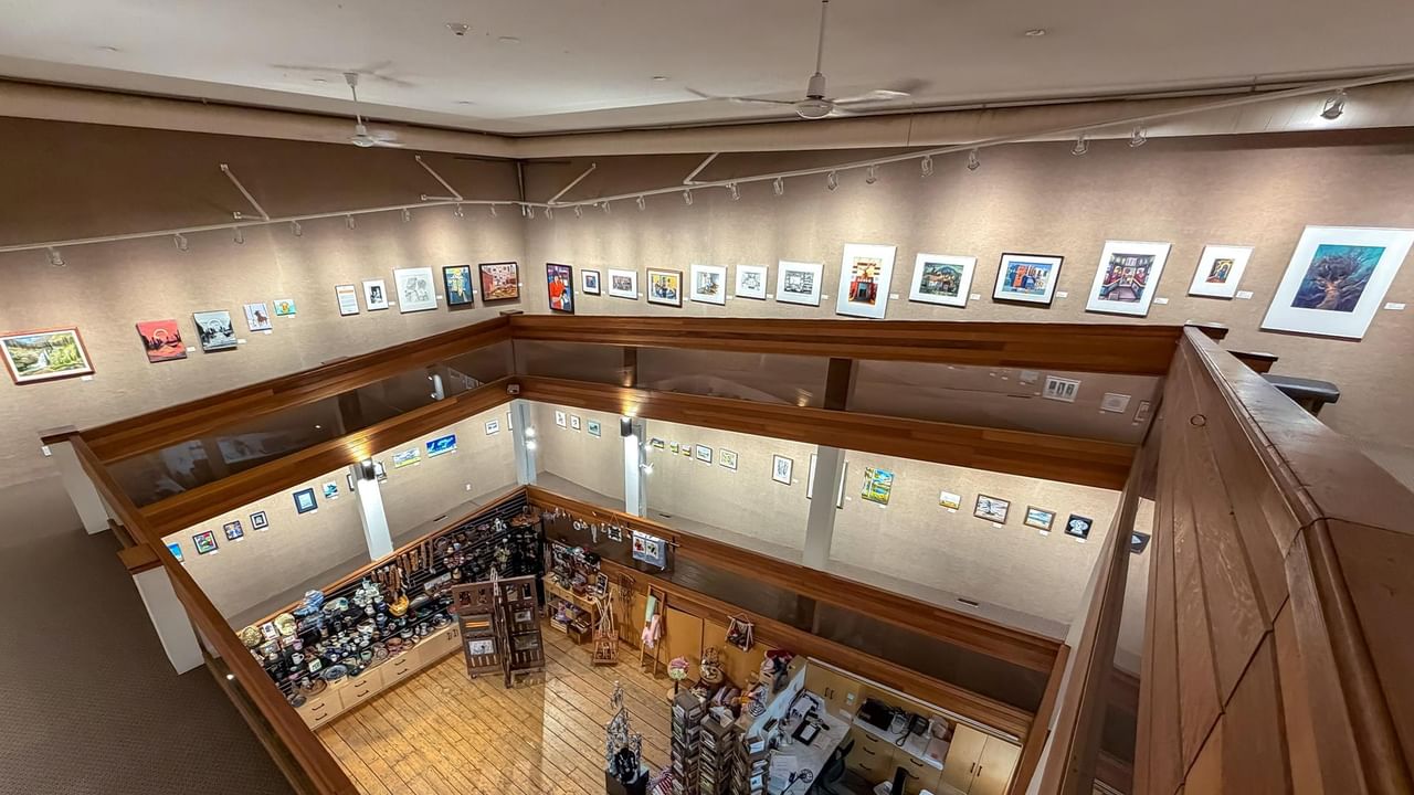 An upper-level view of Dawson Creek Art Gallery with art pieces on walls.