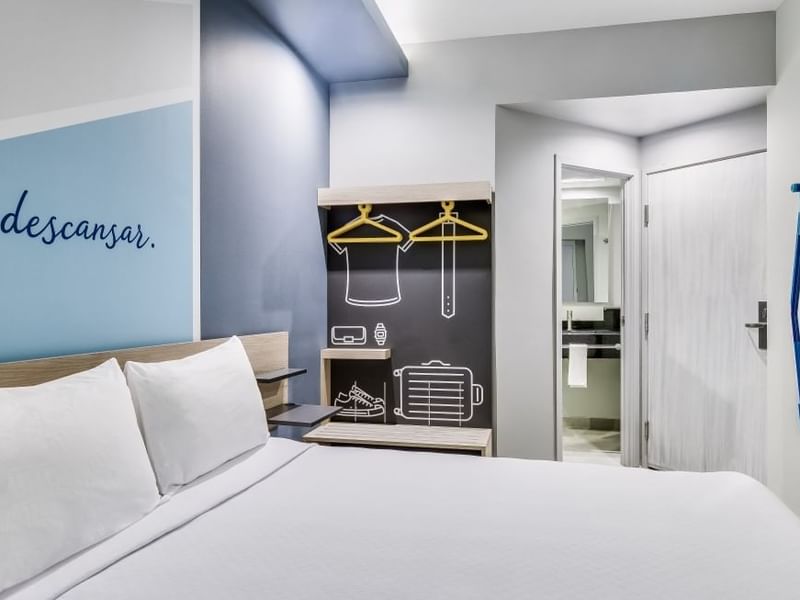 Comfortable bed and minimalist open closet design in a room at One Hotels