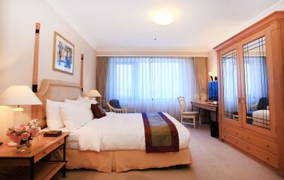 King bed and a wardrobe in Club Suite at Hanoi Daewoo Hotel