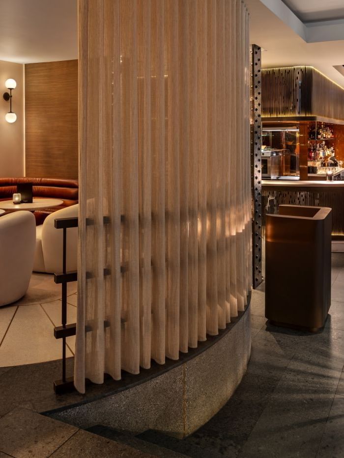 Booth area with cushioned seating and a bar counter at The May Fair Bar