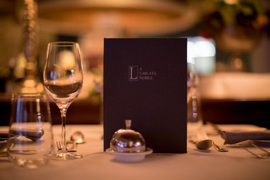 Close-up of a dining setup & a menu in La Cascata at Liebes Rot