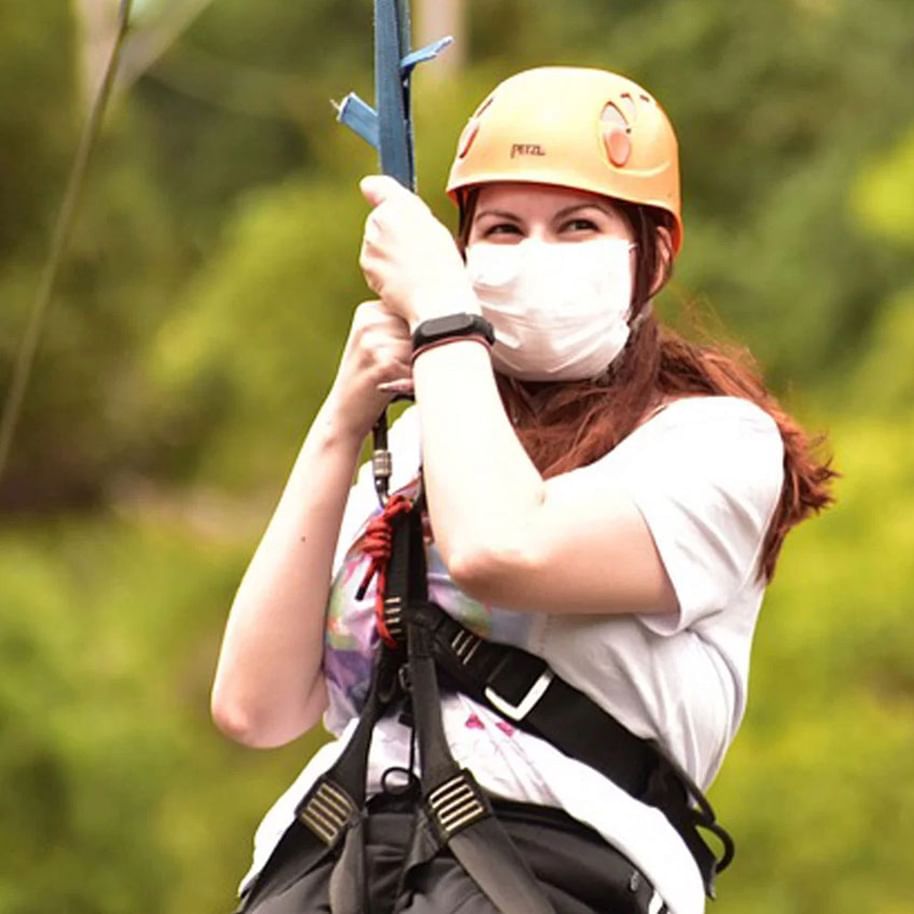 Person in a helmet and harness holding onto a zip line near The Terraces Resort & Spa