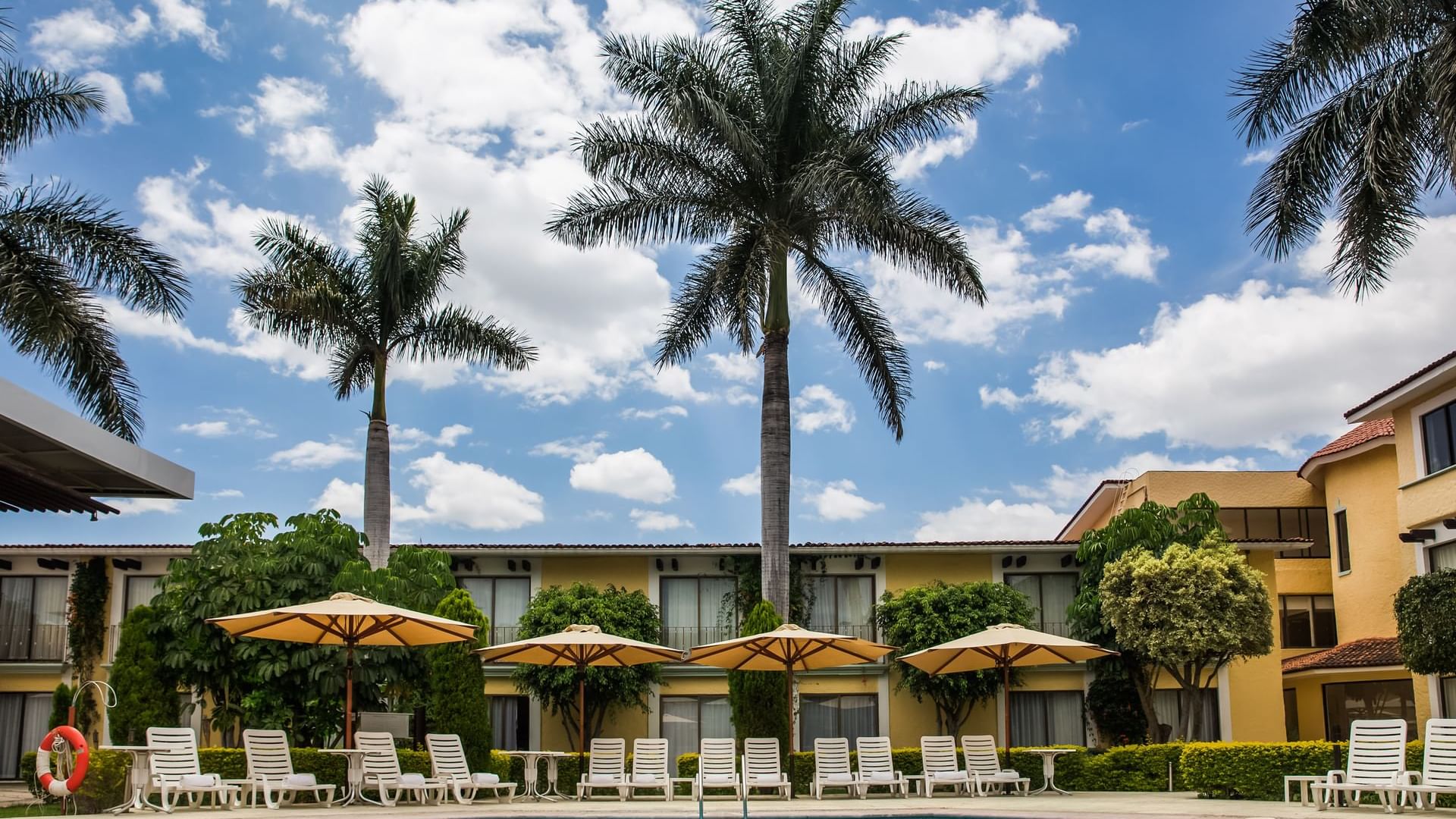Sunbeds by the outdoor pool at Fiesta Inn Oaxaca