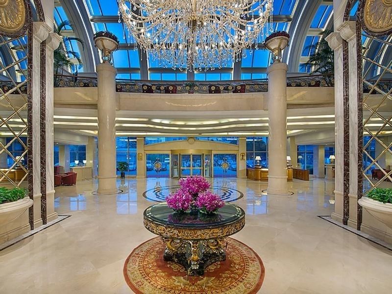 Lobby with high glass ceilings, marble floors under a crystal chandelier at Celebrity International Grand Hotel