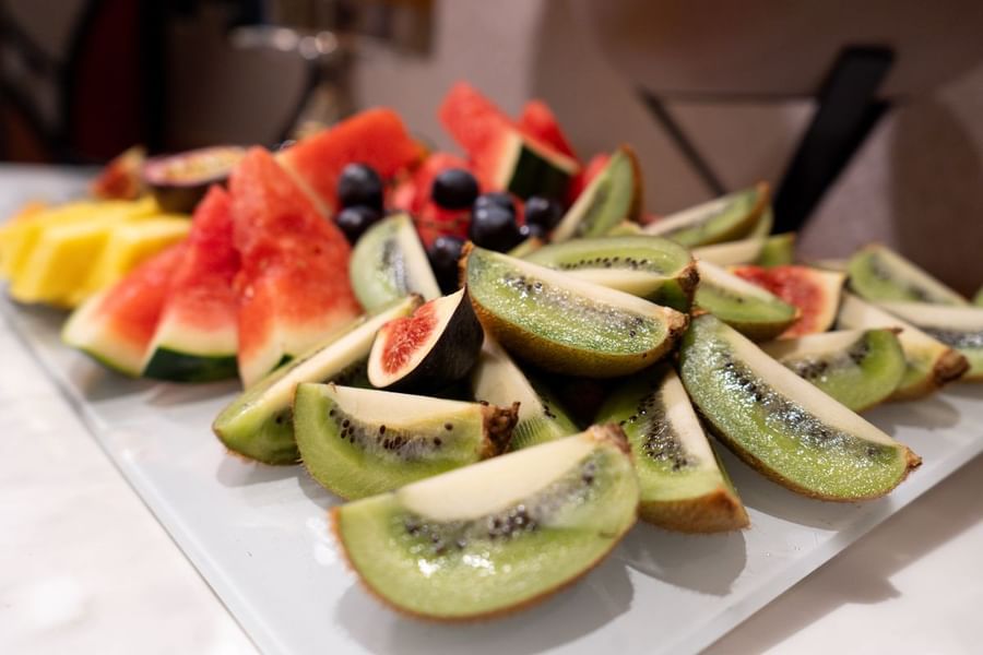 Assiette de fruits frais coupés en morceaux, notamment de la pastèque, des kiwis, des figues et des myrtilles, au Warwick Paris Champs-Élysées