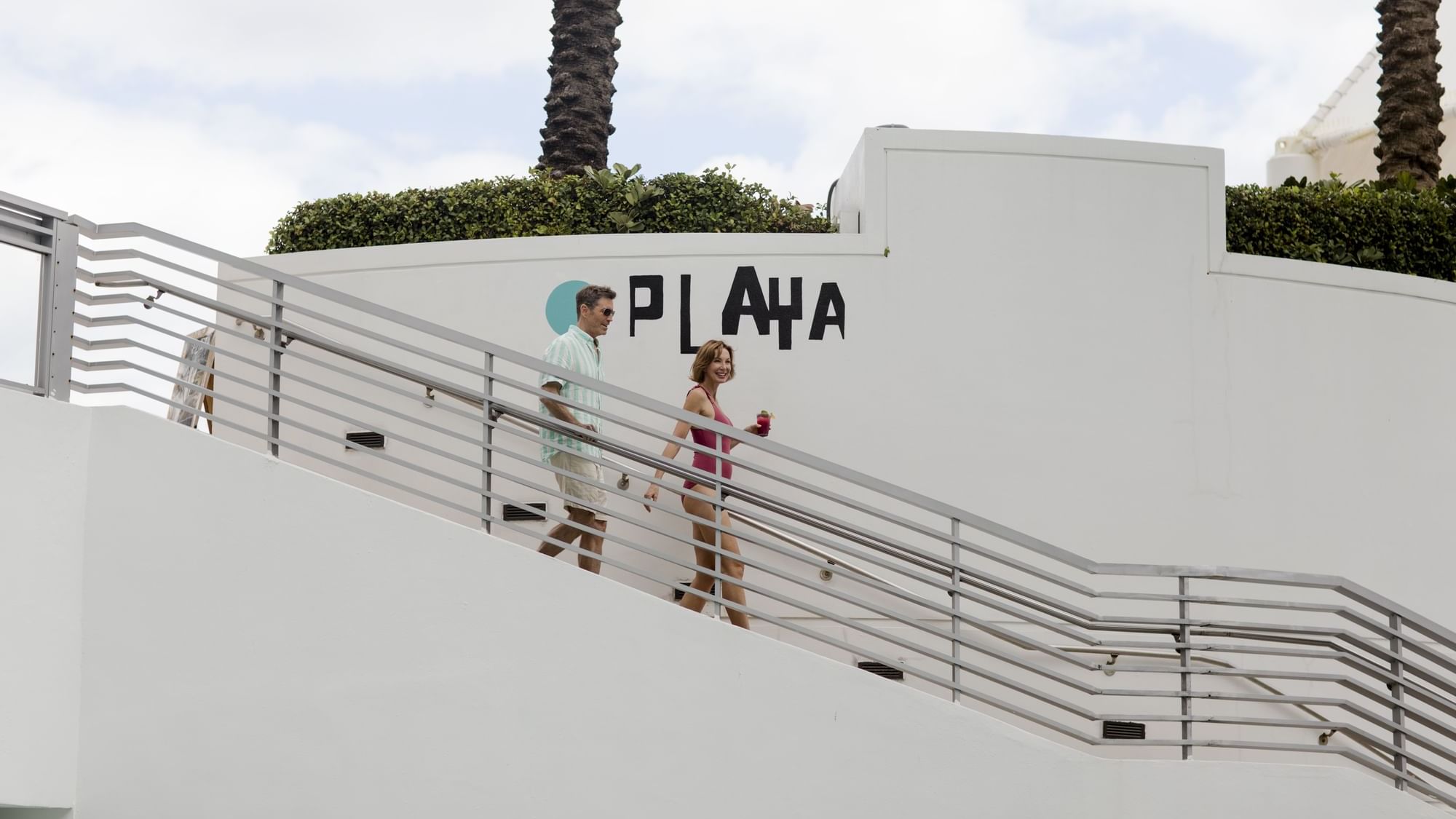 Couple walking to Playa Beachfront Bar & Grill at The Diplomat Resort