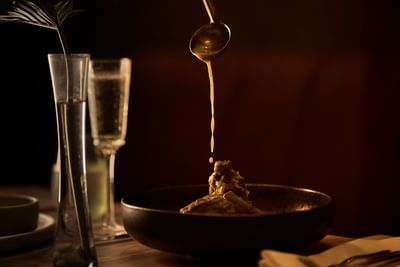 : A sophisticated gourmet dish being served in the elegant atmosphere of La Perla oceanfront restaurant.