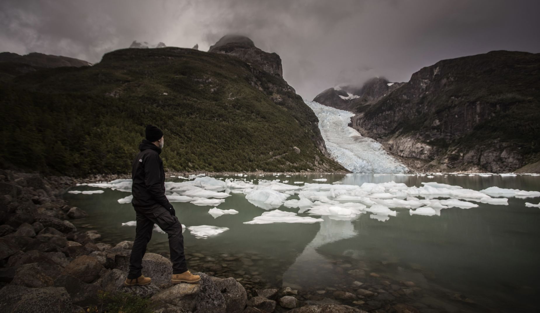 A man at coast watching glaciers near The Singular Patagonia