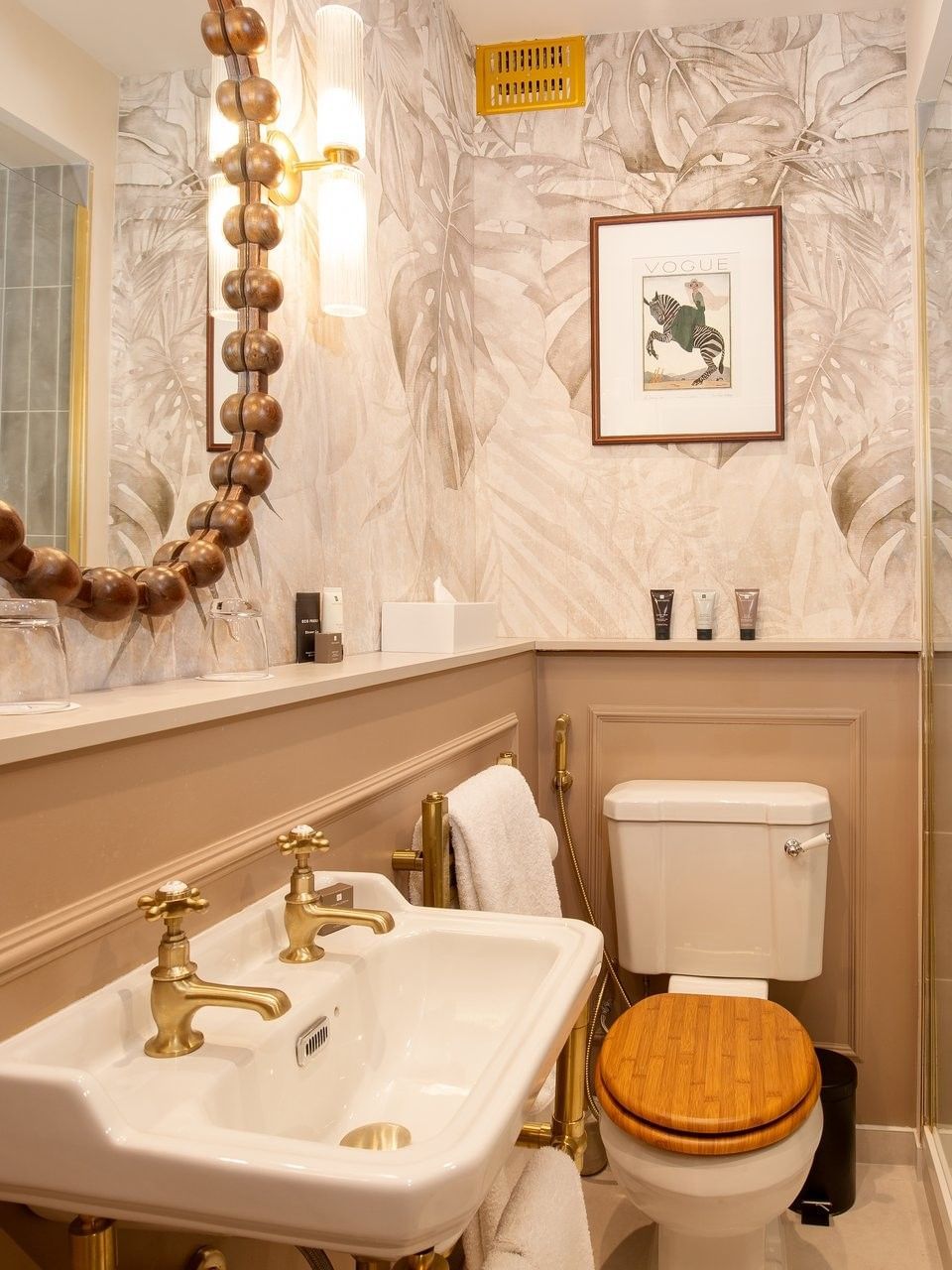 Elegant bathroom with a white sink, wooden toilet, and a shower at The Capital Hotel, Apartments & Townhouse - London.
