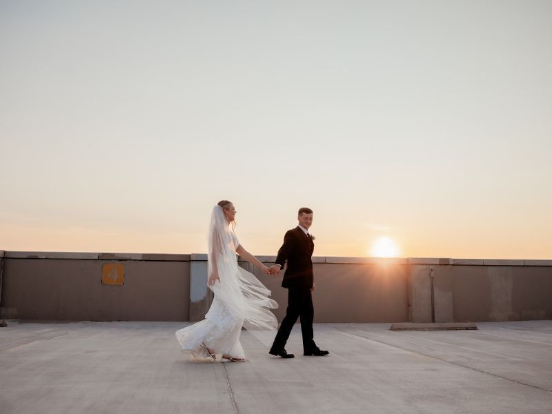 Bride and groom walking together at sunset