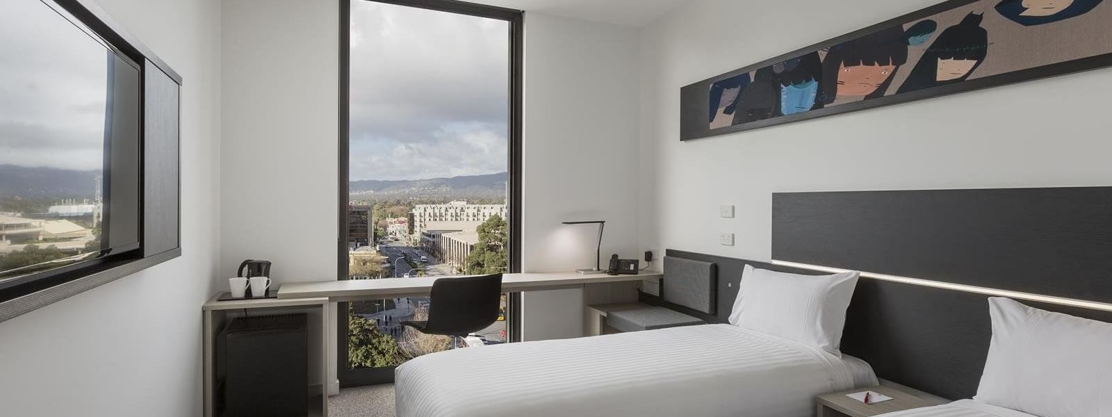 TV facing two beds and workspace by the window with city view in Superior Room, Two Single Beds City View at Ibis Adelaide