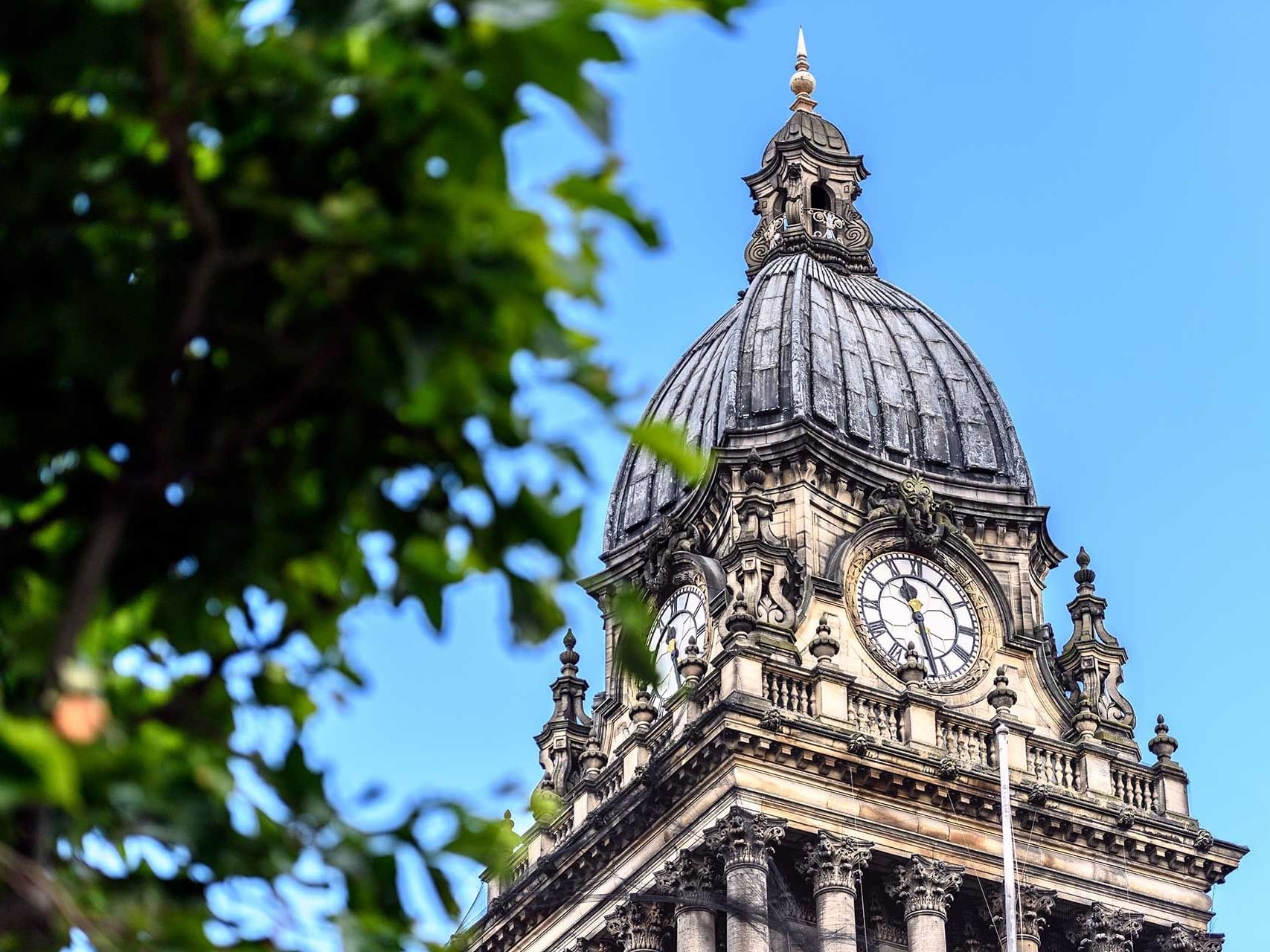 Low-angle shot of Leeds Town Hall clock tower near Met Hotel