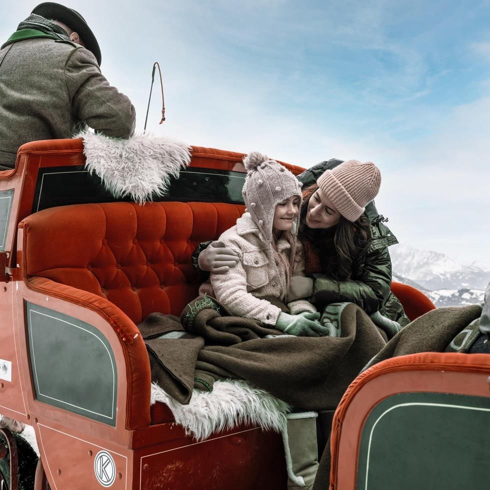 Mom & daughter on a sleigh ride near Falkensteiner Hotels