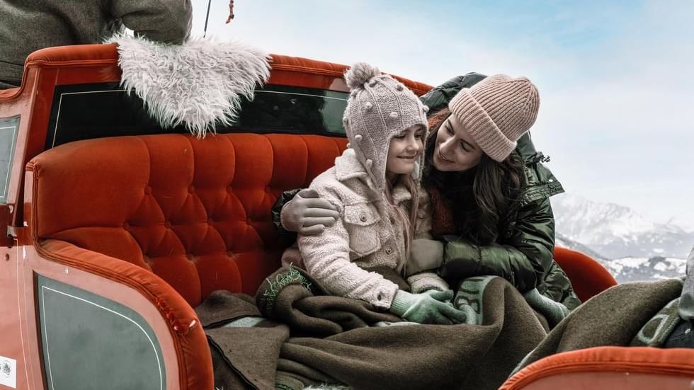 Mom & daughter on a sleigh ride near Falkensteiner Hotels
