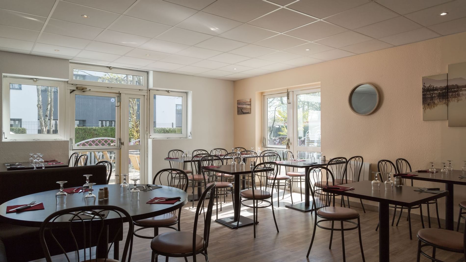 Arranged chairs & tables with glasses at The Originals Hotels