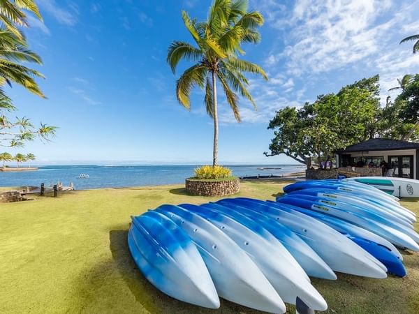 A collection of Kayaks by the ocean at The Naviti Resort
