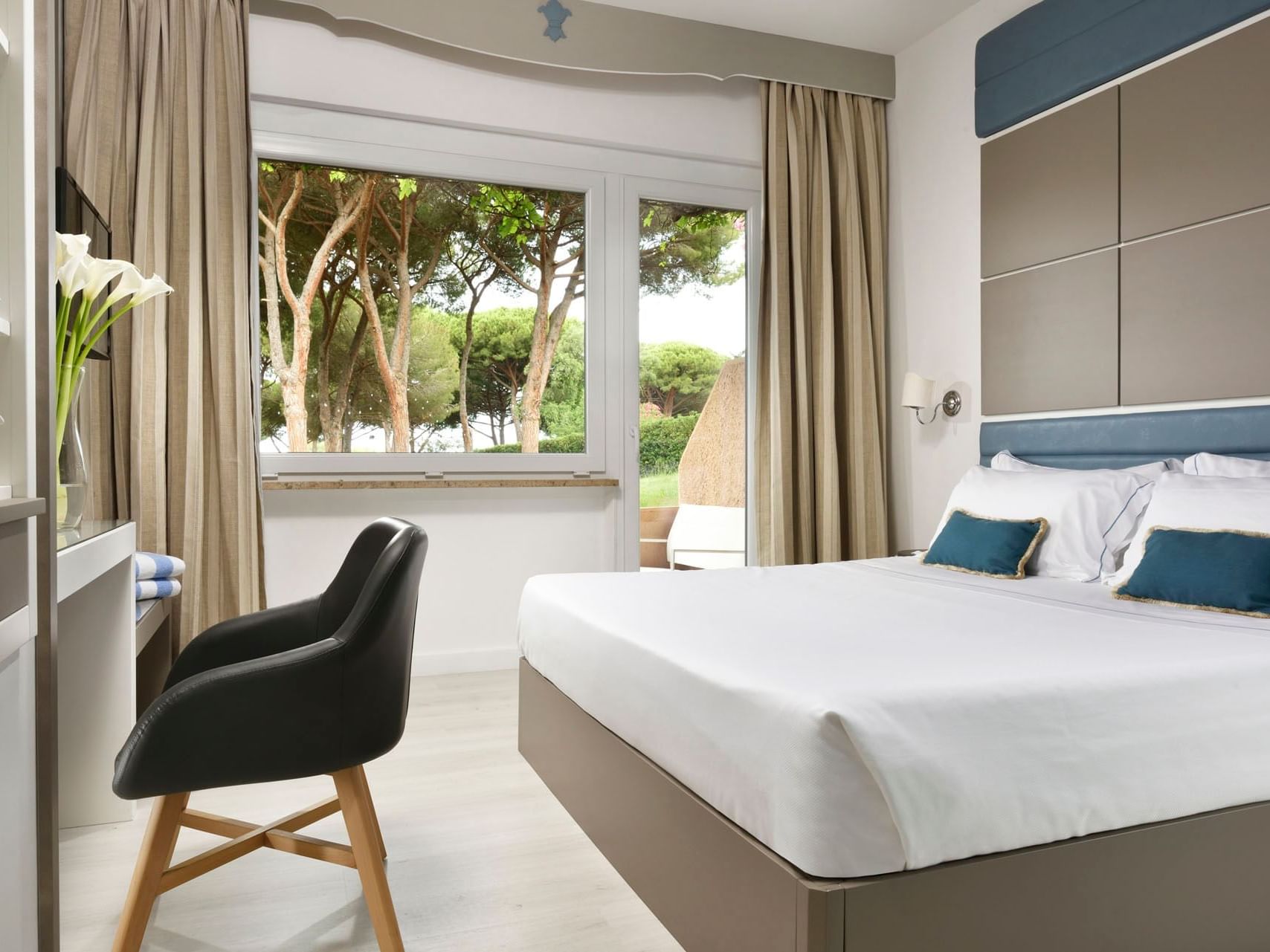 King bed, working space & patio in a Suite at Golf Hotel Punta Ala