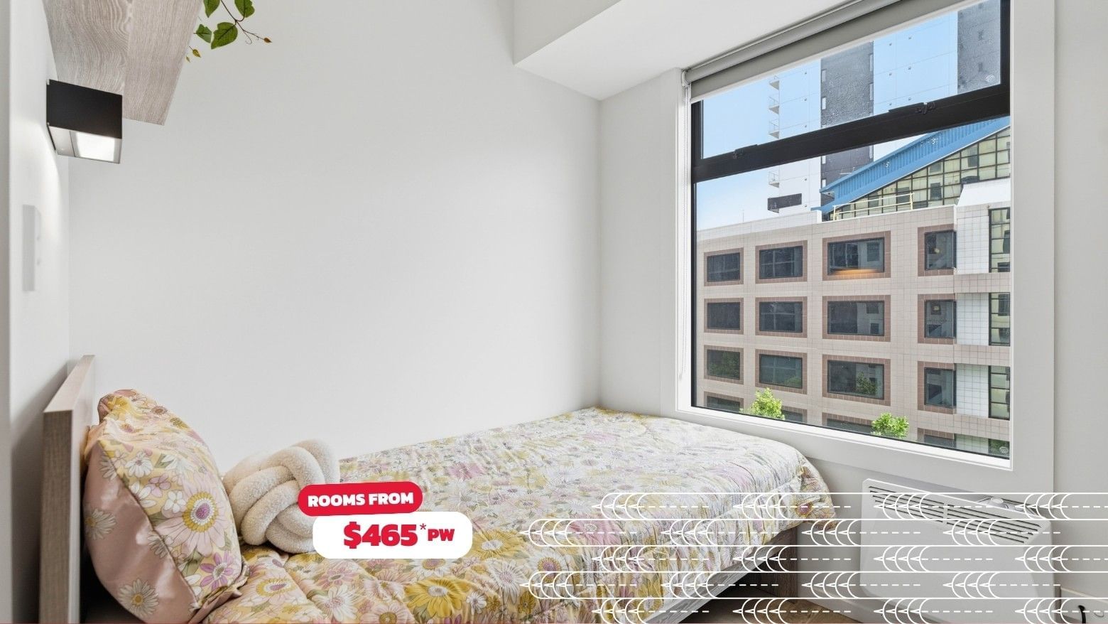 Simple room with bed, window, and floral blanket at Mayoral Drive Student Accommodation.