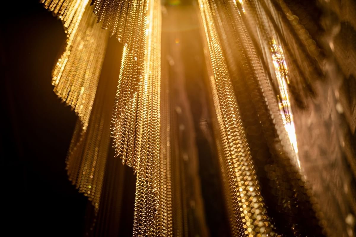 Stunning close-up of golden chains used as a decorative design element at The Londoner Hotel