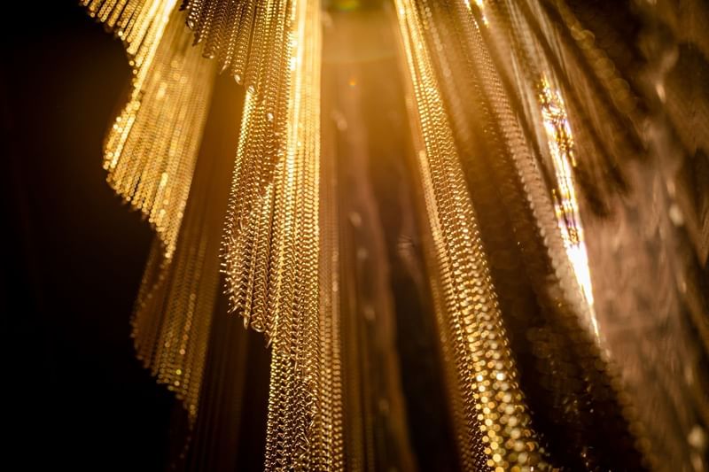 Stunning close-up of golden chains used as a decorative design element at The Londoner Hotel