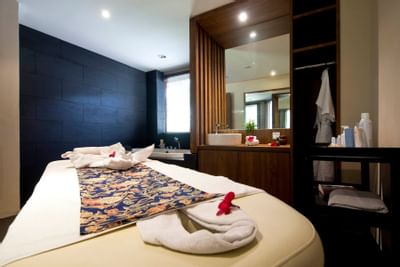 A massage table in the spa with towels and a sink