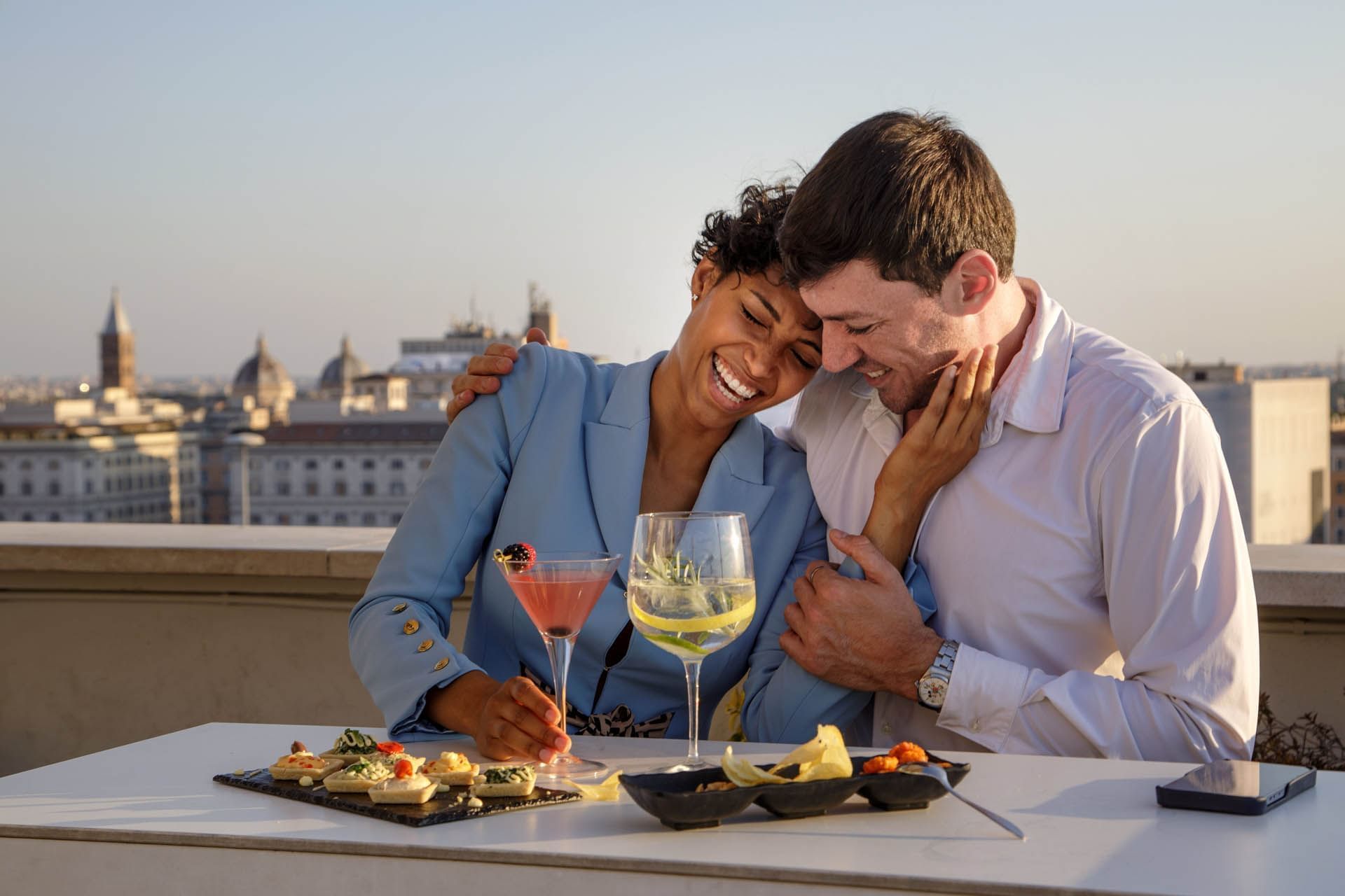 Couple enjoying drinks and food with a city view at Terrazza Cielo rooftop, The Independent
