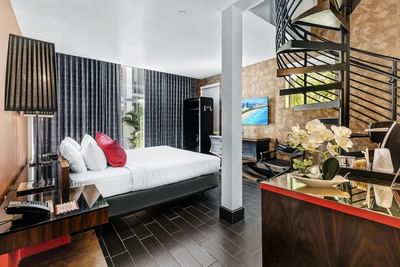 King-size bed, TV, and a spiral staircase to the rooftop in Premium King with Rooftop Terrace at Fairwind Hotel Miami