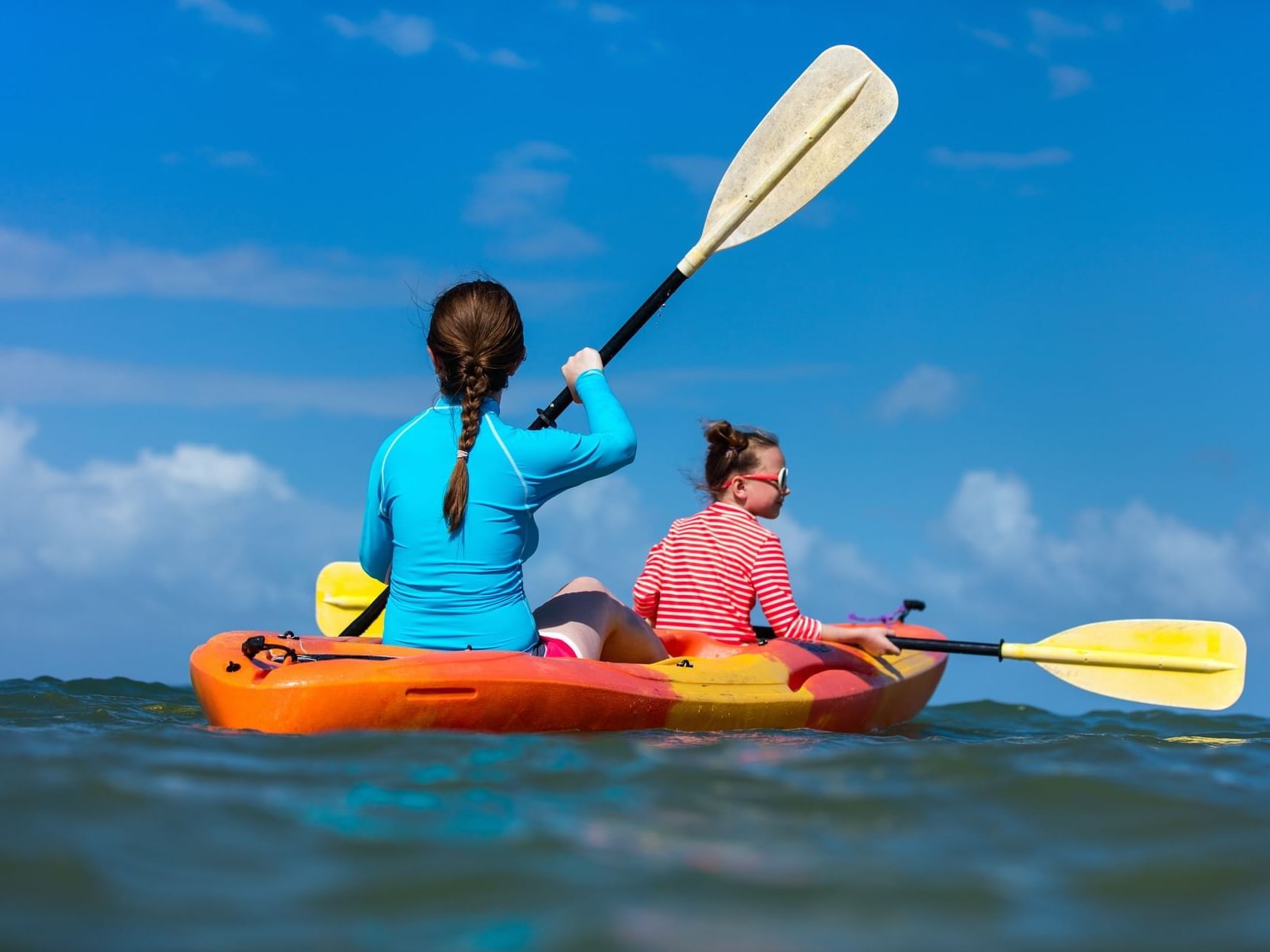 Two girls kayaking in the sea near ICONA Hotel Windrift