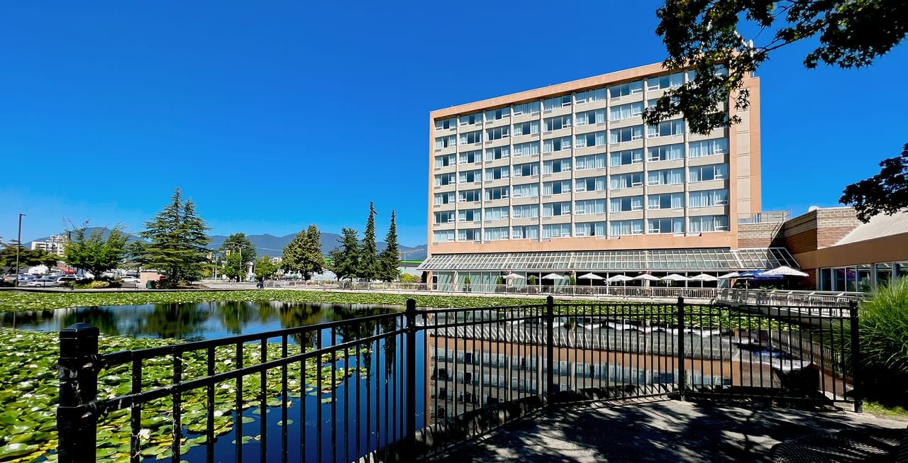Exterior of Coast Chilliwack Hotel by APA with pond and greenery
