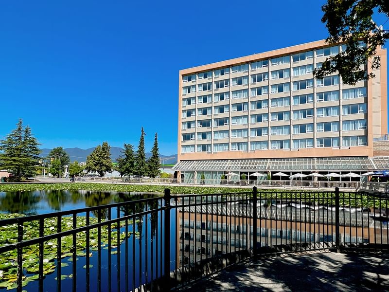 Exterior of Coast Chilliwack Hotel by APA with pond and greenery