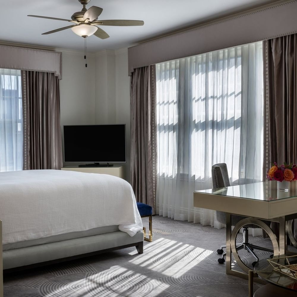 Presidential Suite at Warwick Melrose in Dallas with a large bed, desk, and bright windows.