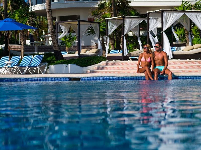A couple relaxing on the pool at The Reef playacar