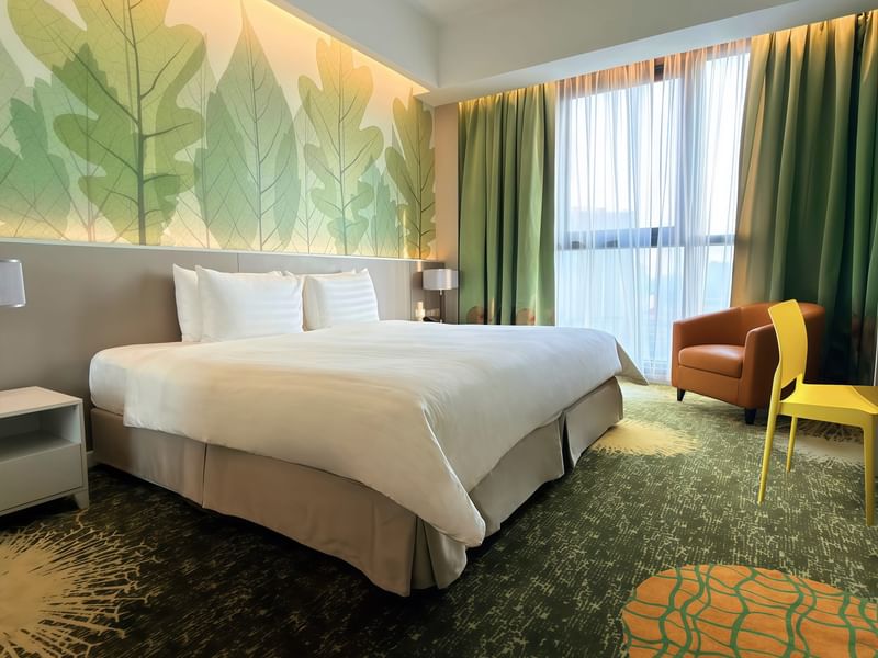 Deluxe Plus King Room with a large bed, chairs, and scenic window at Sunway Velocity Hotel in Kuala Lumpur.