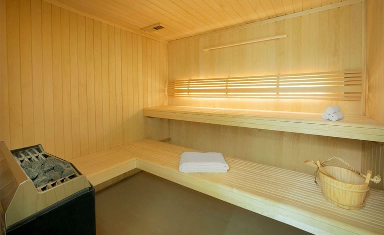 Wooden sauna bench with essentials in the spa at DAMAC Maison Canal Views