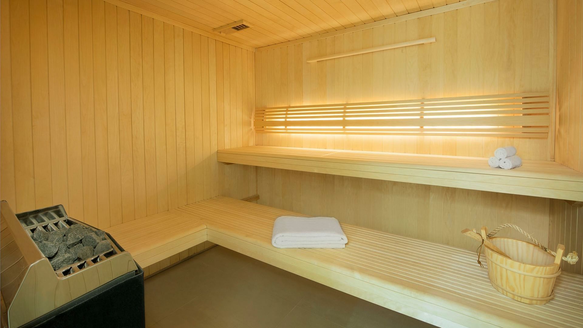 Wooden sauna bench with essentials in the spa at DAMAC Maison Canal Views