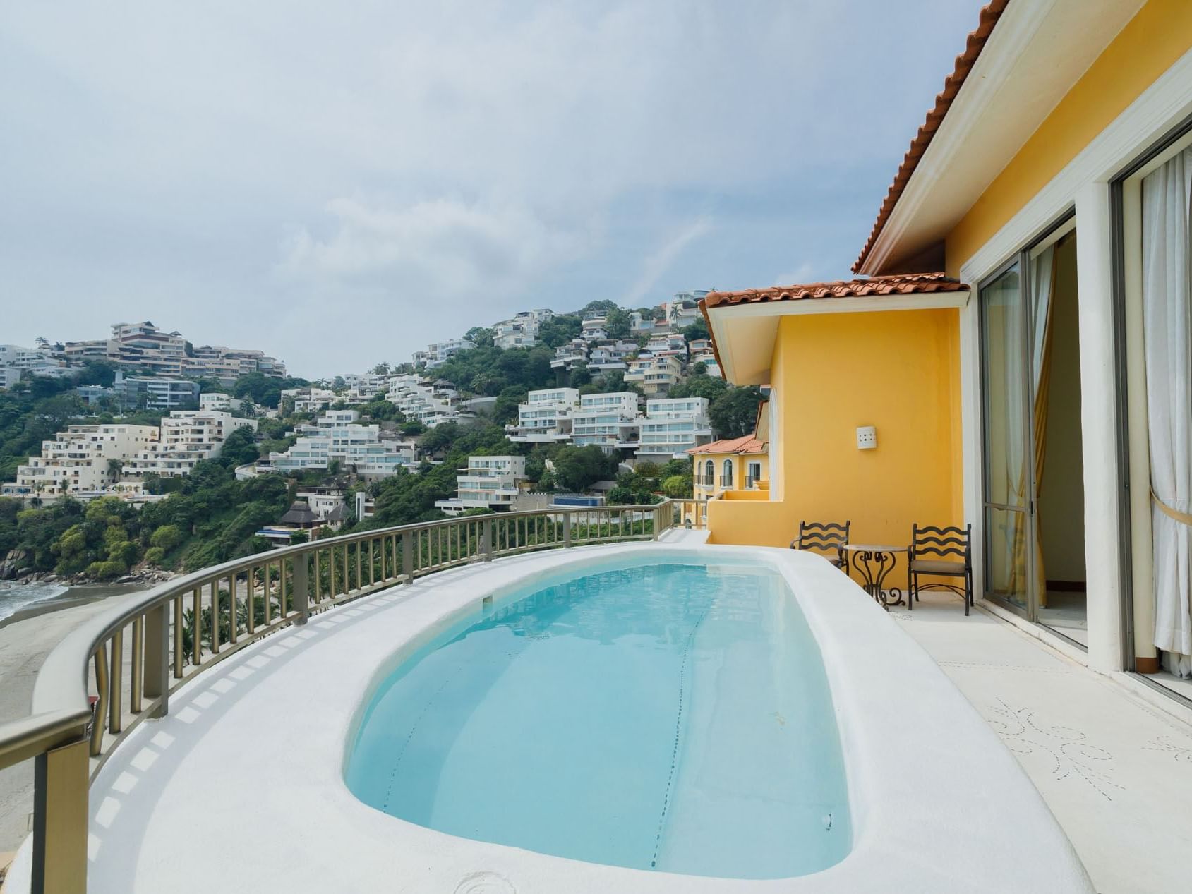 Rooftop pool in King Presidential Suite overlooking white hillside villas and the beautiful blue bay at Quinta Real Acapulco