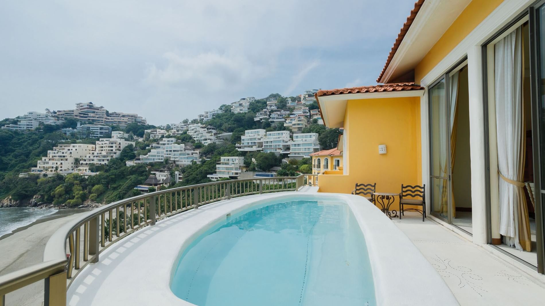 Rooftop pool in King Presidential Suite overlooking white hillside villas and the beautiful blue bay at Quinta Real Acapulco