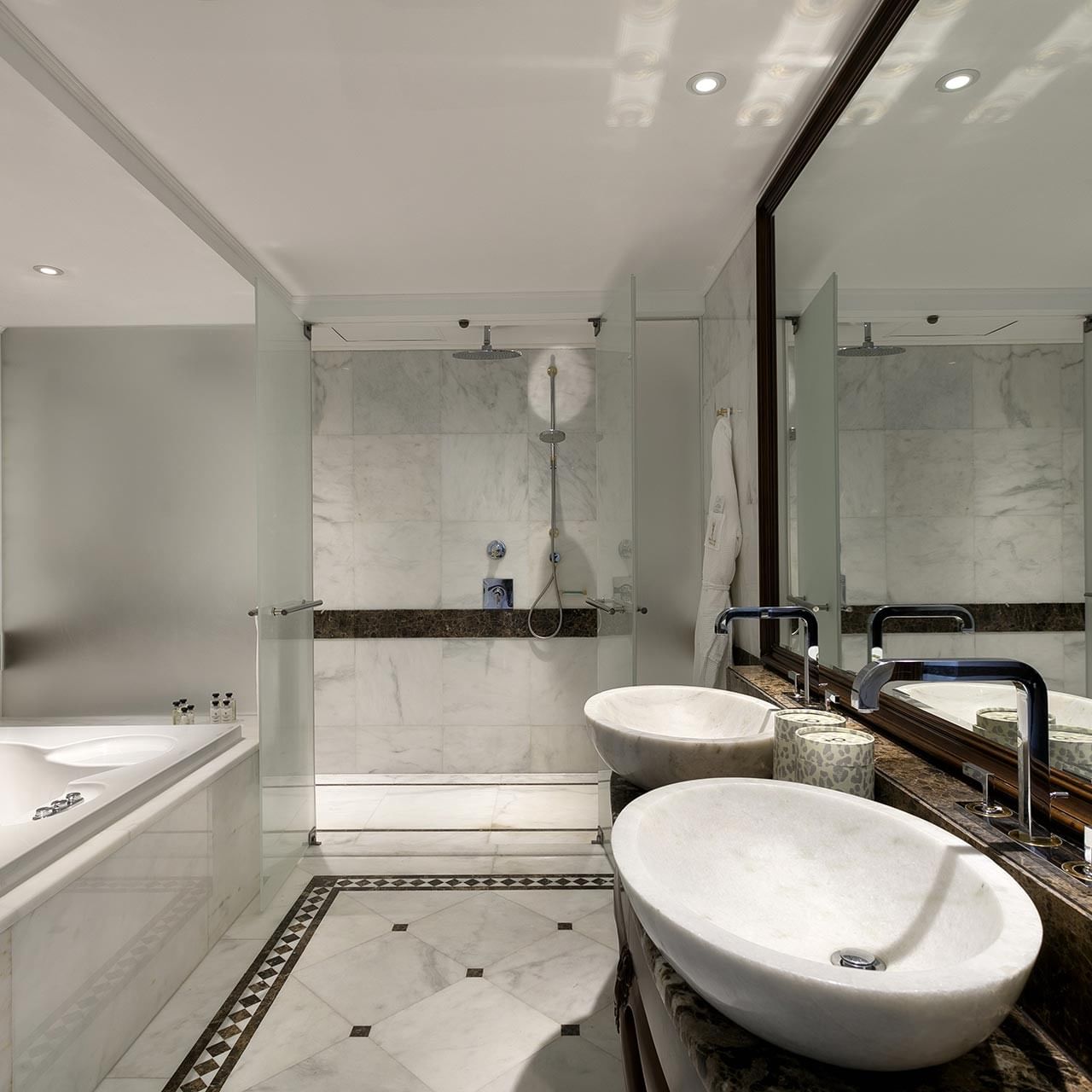 Просторная ванная комната с ванной, двумя раковинами и зеркалом, отражающим интерьер, в гранд двухуровневом люксе