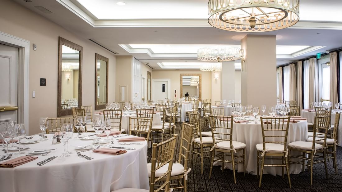 Courtyard Ballroom at El Prado Hotel, set for an event with white linen tables and gold chairs