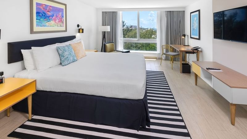 King-size bed, work desk & a TV in Island View at Warwick Paradise Island Bahamas