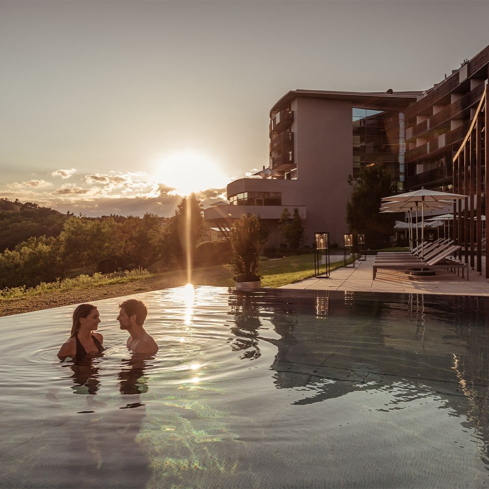 Couple enjoying in the Infinity Pool at Falkensteiner Balance Resort Stegersbach