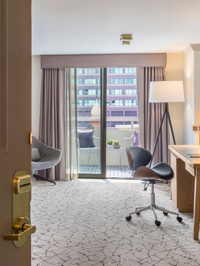 View of Accessible Deluxe Rooms by a balcony under a tripod lamp through an open doorway at Warwick Denver