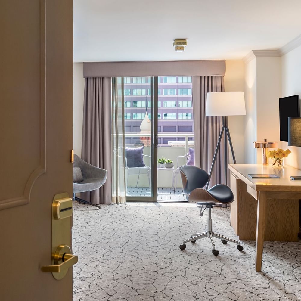 View of Accessible Deluxe Rooms by a balcony under a tripod lamp through an open doorway at Warwick Denver